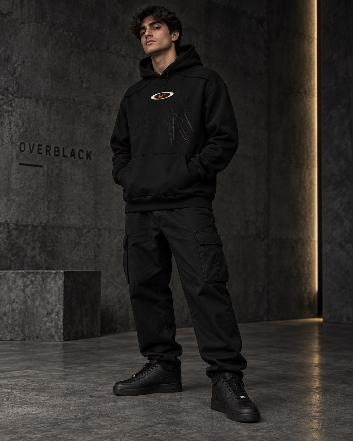 Modelo con hoodie negro, pantalón cargo y zapatillas negras